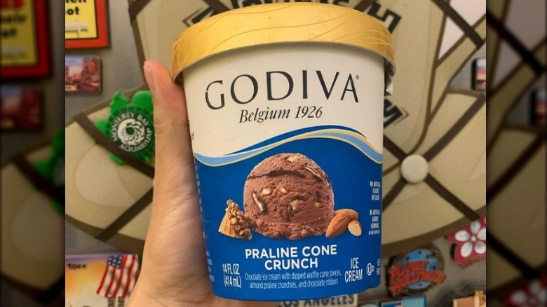 hand holding pint of Godiva ice cream