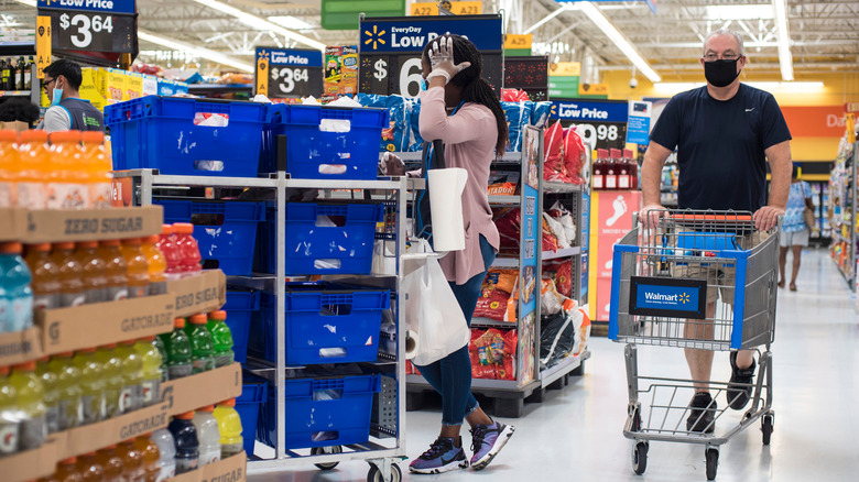 masked man and staff shopping in Walmart's grocery section