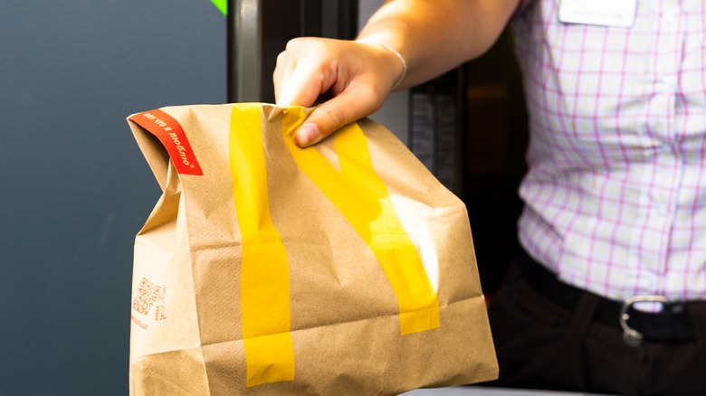 Employee handing McDonald's bag through window