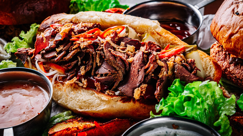 Philly cheesesteak with sauces in condiment cups