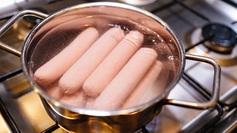 Hot dogs simmering in pot of water