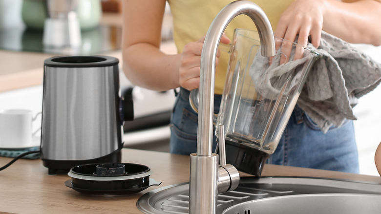 A woman cleaning a blender 