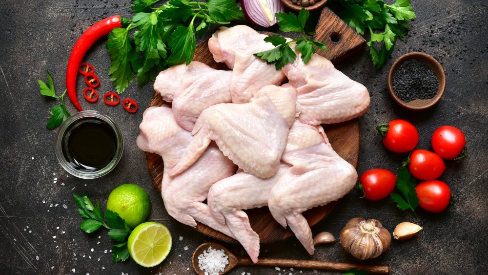 raw chicken wings on platter with ingredients