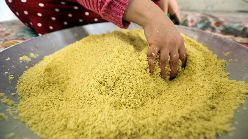 A woman sifts through couscous