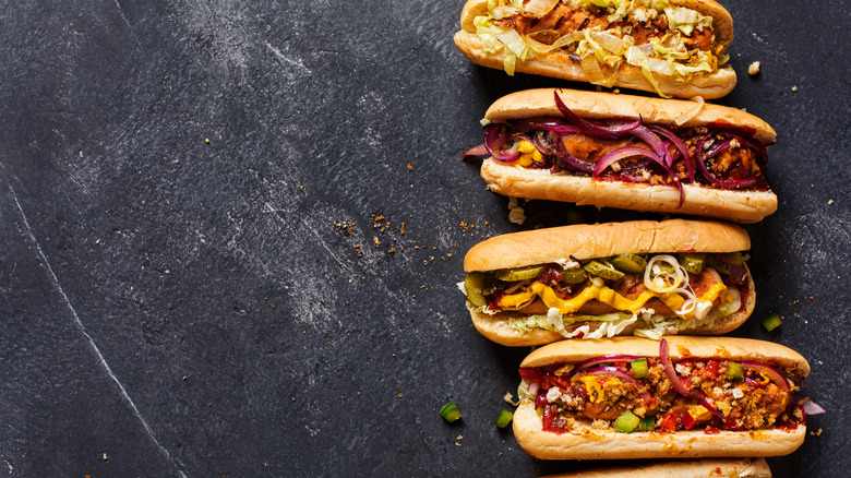 loaded hot dogs on a black background