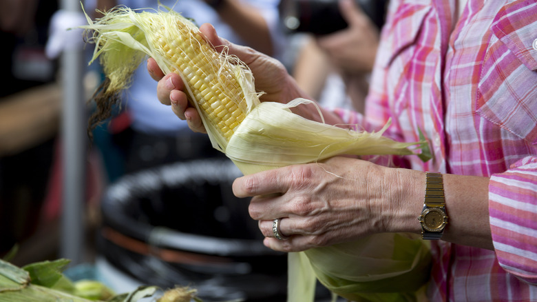 woman shucking corn