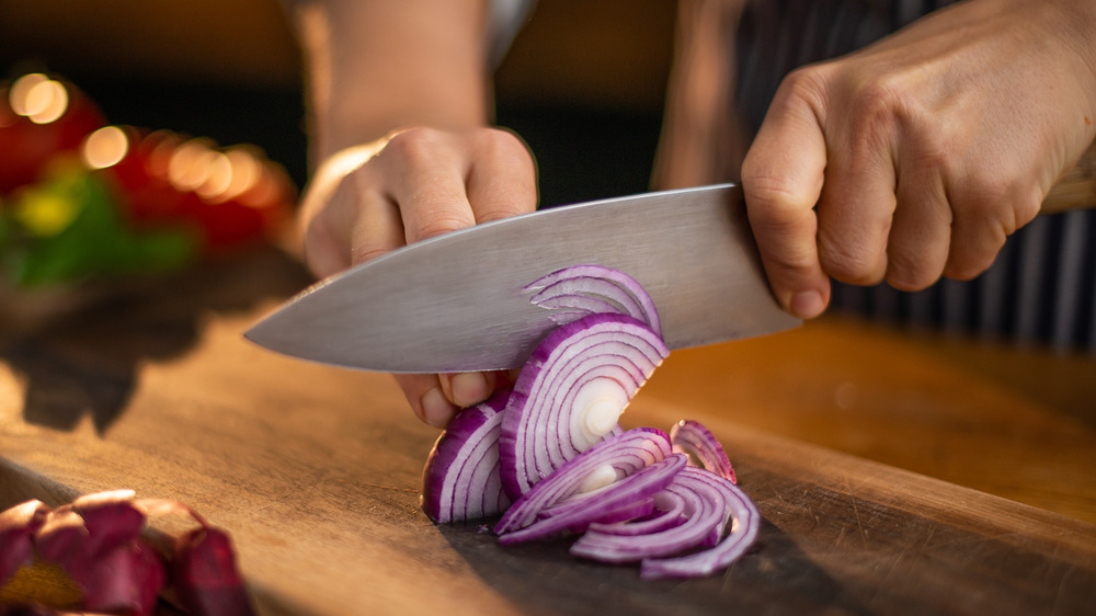 Person chopping red onion