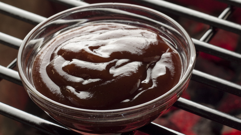 A bowl of barbecue sauce on a grill