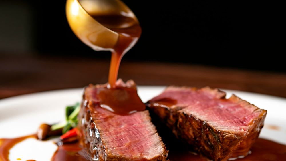 pouring sauce over pan seared steak