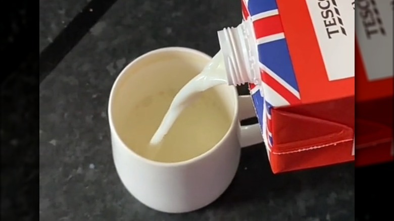 Pouring milk from upside down carton into mug