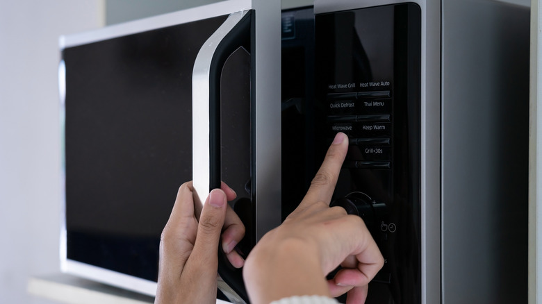 Woman setting a microwave 