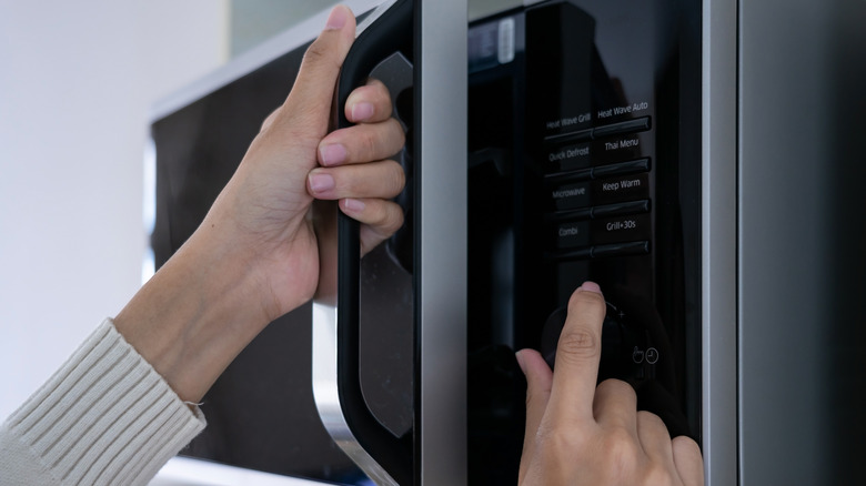 Woman programming a microwave