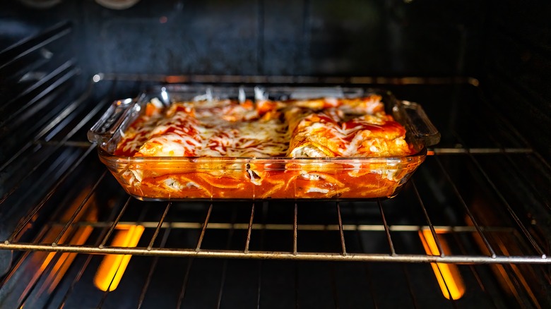 Enchiladas baking in glass dish in oven