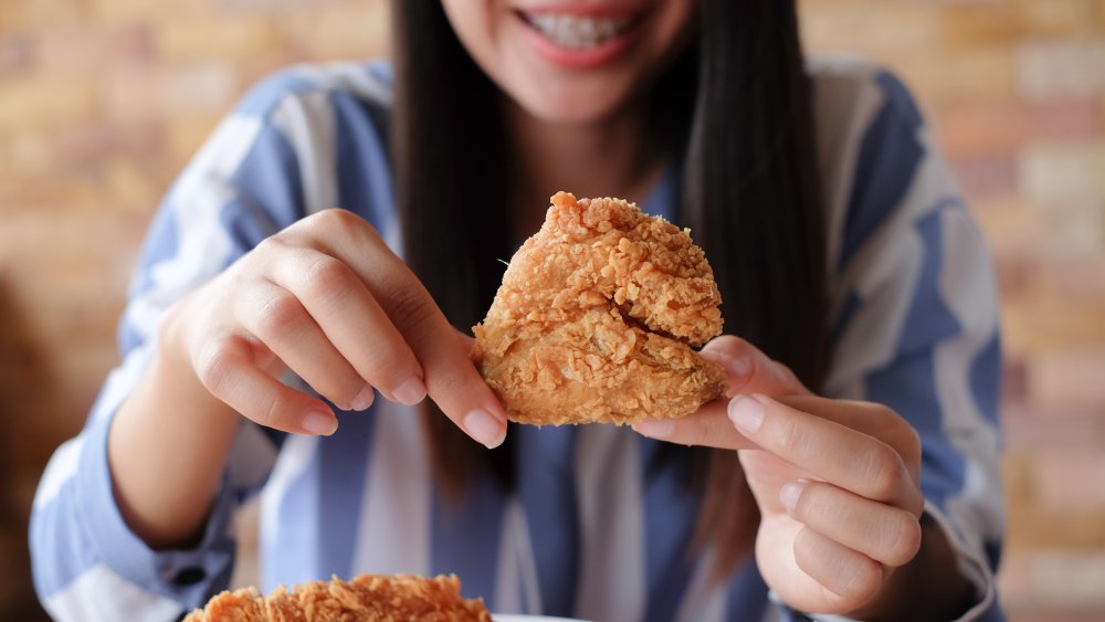 woman holding fried chicken