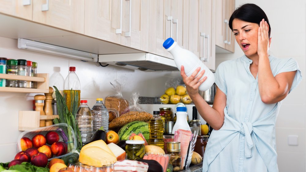 Woman looking at milk's expiration date