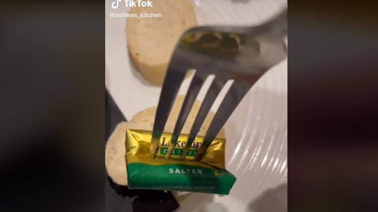 butter packet being stabbed with fork