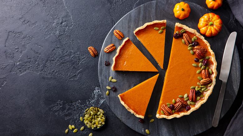 pumpkin pie on cutting board with knife