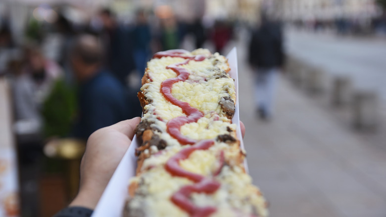 person holding zapiekanka in Warsaw